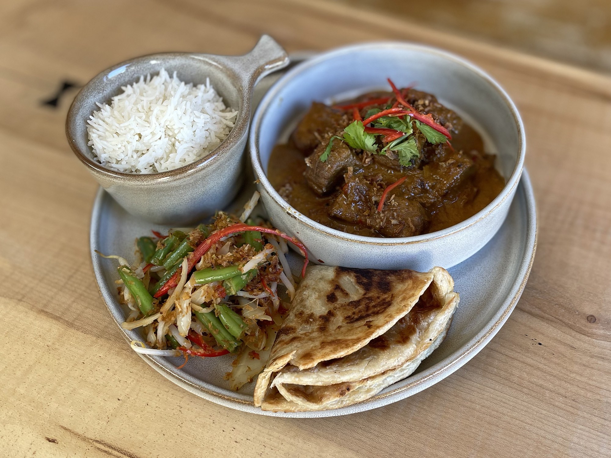 Rich curry with rice, roti and vegetables