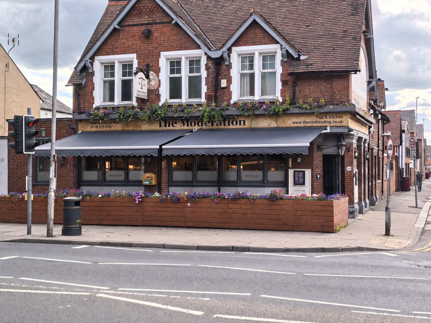 The Moderation pub exterior with flower planters and covered terrace